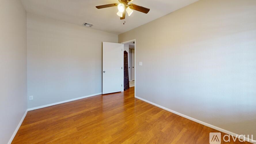 A room with wooden floors and a ceiling fan.