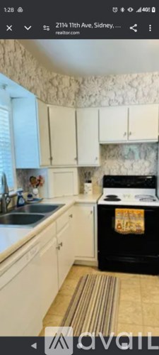 A kitchen with a black oven and white cabinets.