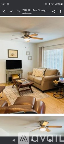 A living room with a brown leather couch and a wooden coffee table.
