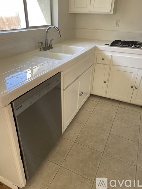 A kitchen with a dishwasher and a stove top oven.