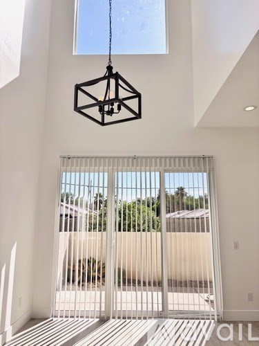 A modern house with a white gate and a hanging light fixture.