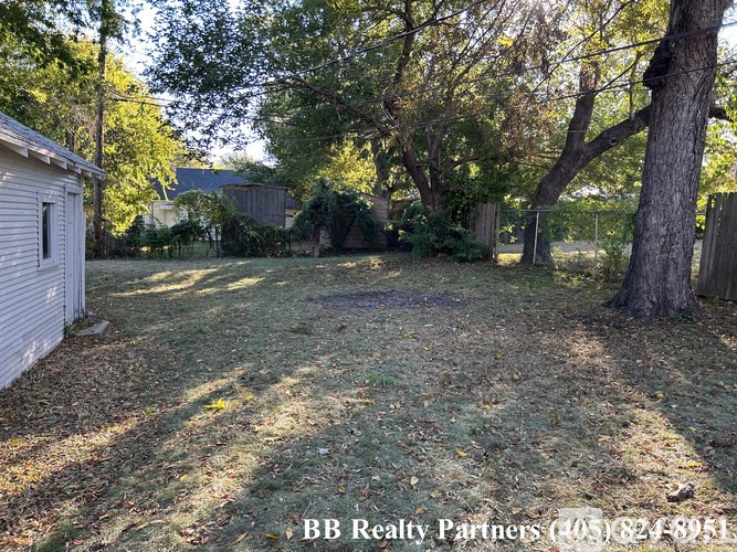 A backyard with a shed, trees, and a fence.