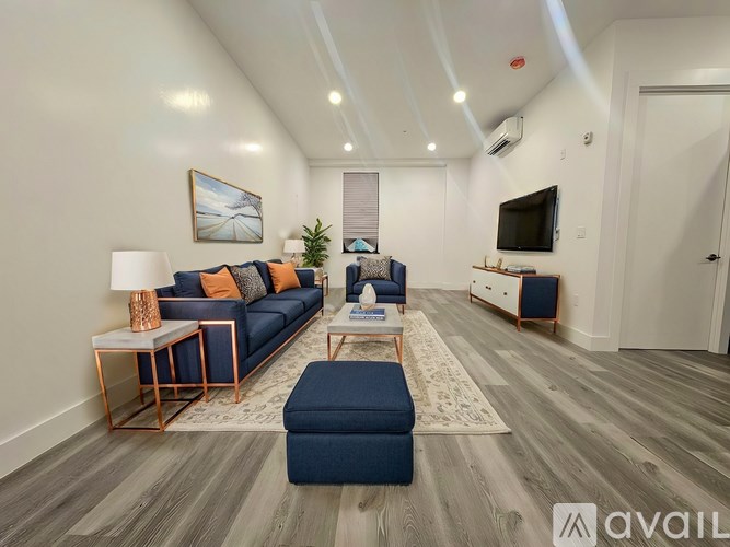 A living room with a blue couch, a coffee table, and a television.