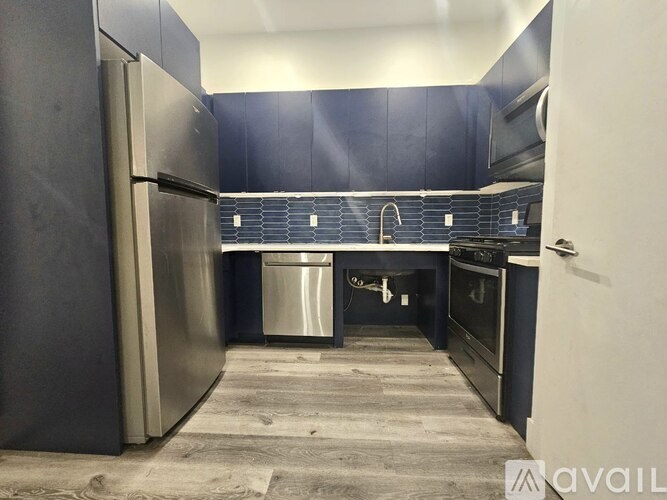 A kitchen with a refrigerator, oven, and sink.