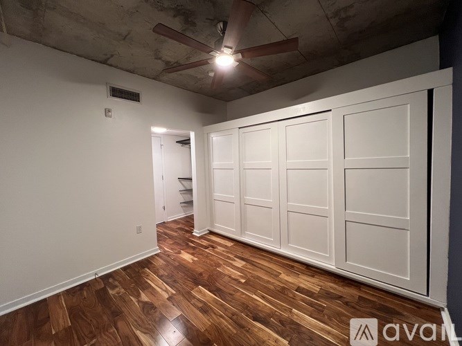 A room with wooden floors and a ceiling fan.