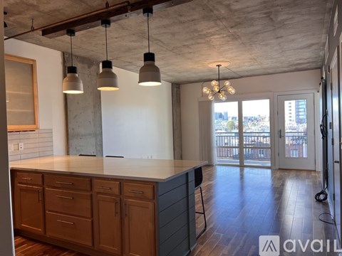 A kitchen with wooden cabinets and a concrete ceiling.