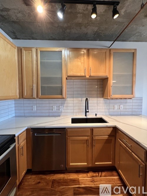 A kitchen with wooden cabinets and a stainless steel sink.