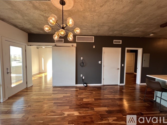 A room with a wooden floor and a chandelier hanging from the ceiling.