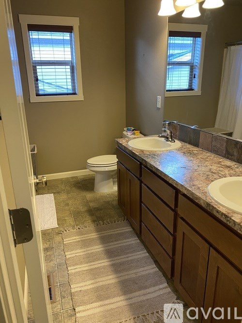 A bathroom with a toilet, sink, and mirror.