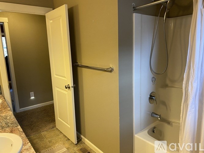 A bathroom with a white door and a white bathtub.