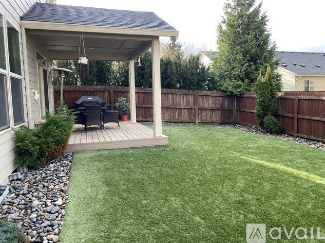 A backyard with a gazebo and a BBQ grill.