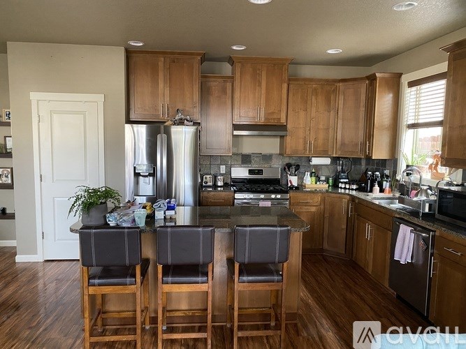 A kitchen with wooden cabinets and a black countertop.