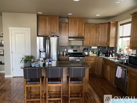 A kitchen with wooden cabinets and a black countertop.