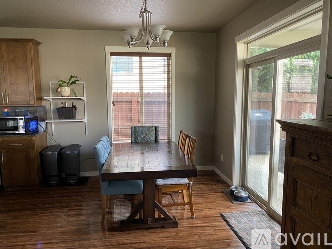 A dining room with a wooden table and chairs.