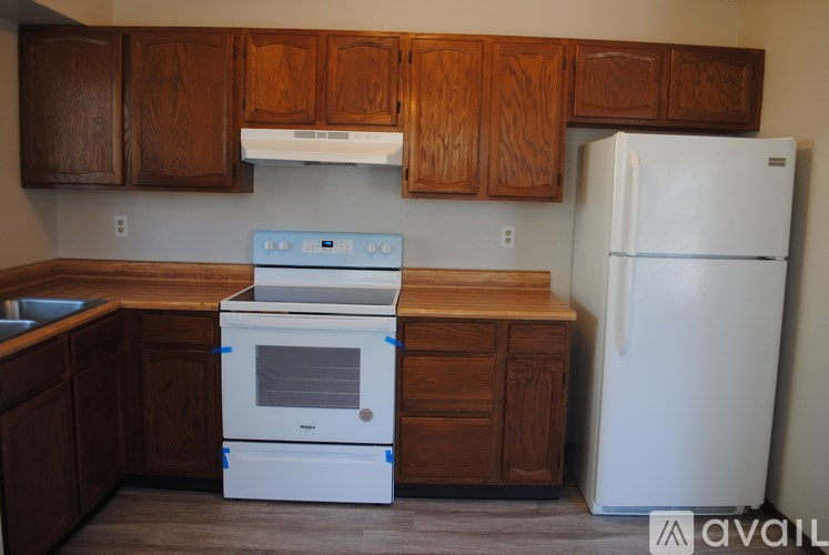 A kitchen with a white oven and refrigerator.