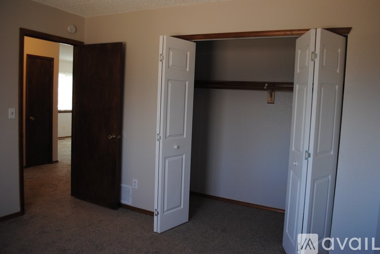 A room with a carpeted floor and two open doors.