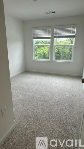 A room with a window and carpeted floor.