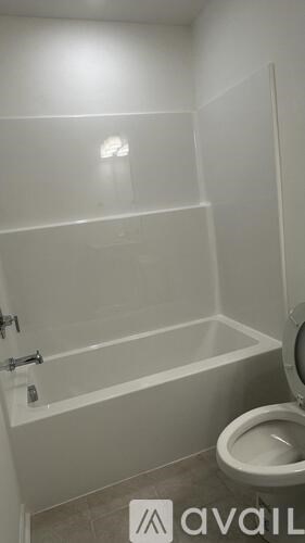 A white bathroom with a toilet and a bathtub.