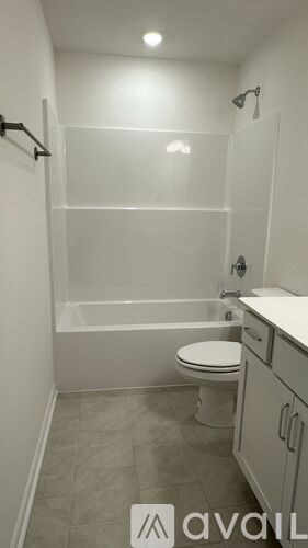 A white toilet is in a bathroom with a walk-in shower.