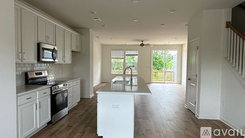 A kitchen with white cabinets and a white fridge.