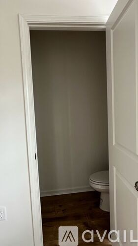 A small bathroom with a toilet and a door.