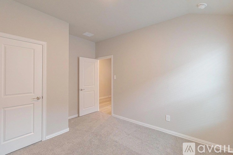 A room with a carpeted floor and two doors, one of which is open.