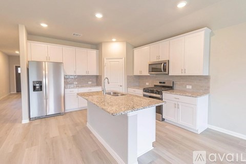 A kitchen with white cabinets and a granite countertop.