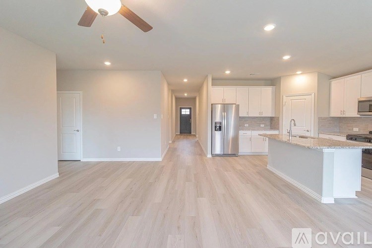 A spacious kitchen with white cabinets and a central island.