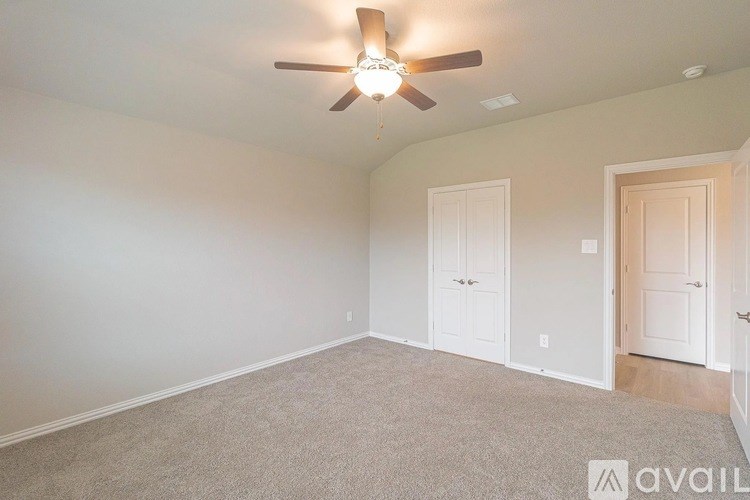 A room with a ceiling fan and carpeted floor.