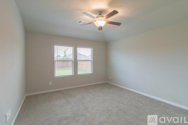 A room with a ceiling fan and carpeted floor.