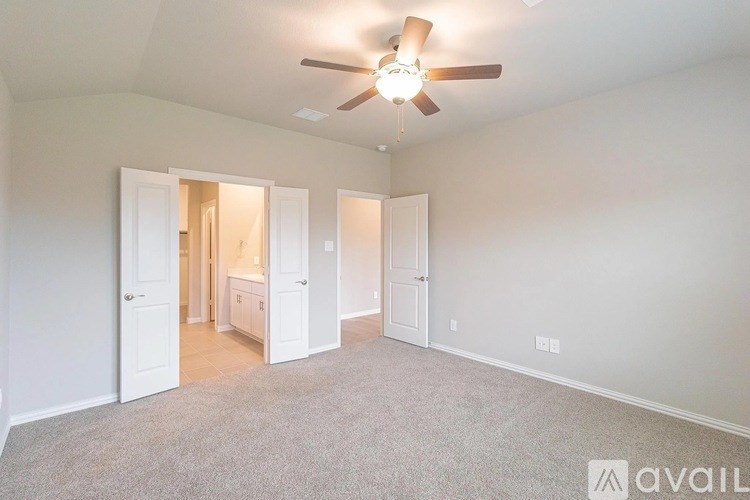 A room with a ceiling fan and carpeted floor.