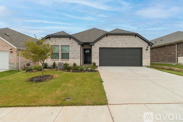 A house with a garage and a tree in front.