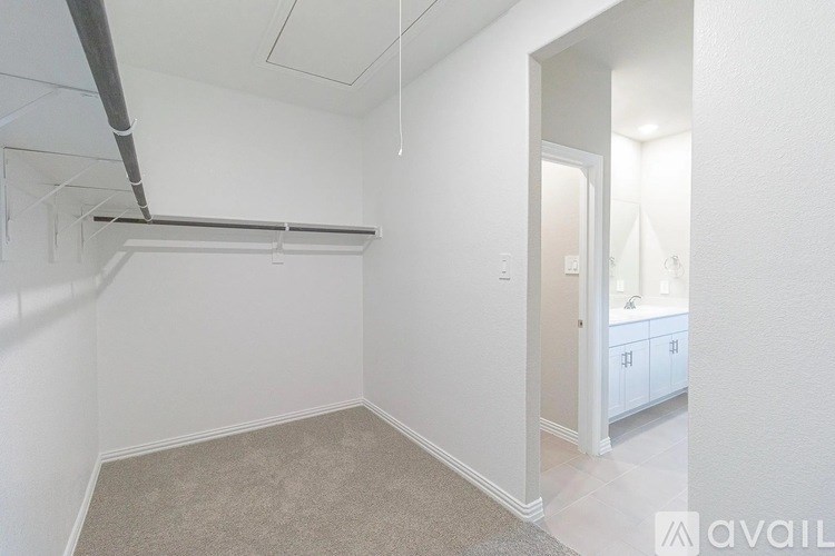 A white room with a carpeted floor and a white door leading to another room.