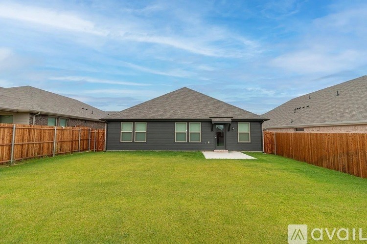 A house with a brown roof and a fence surrounding the yard.