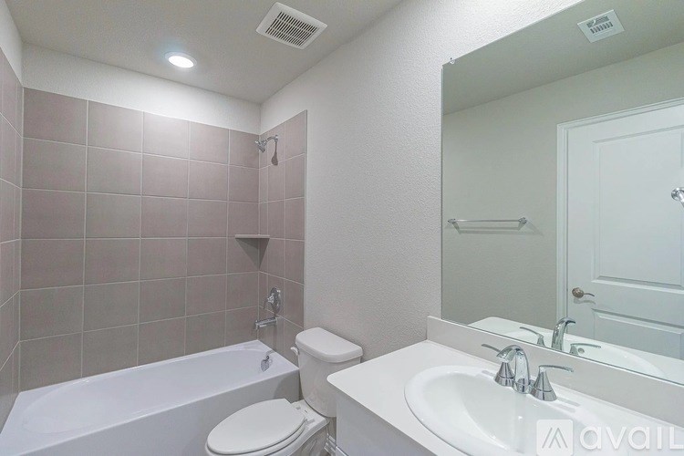 A bathroom with a white tub, toilet, and sink.