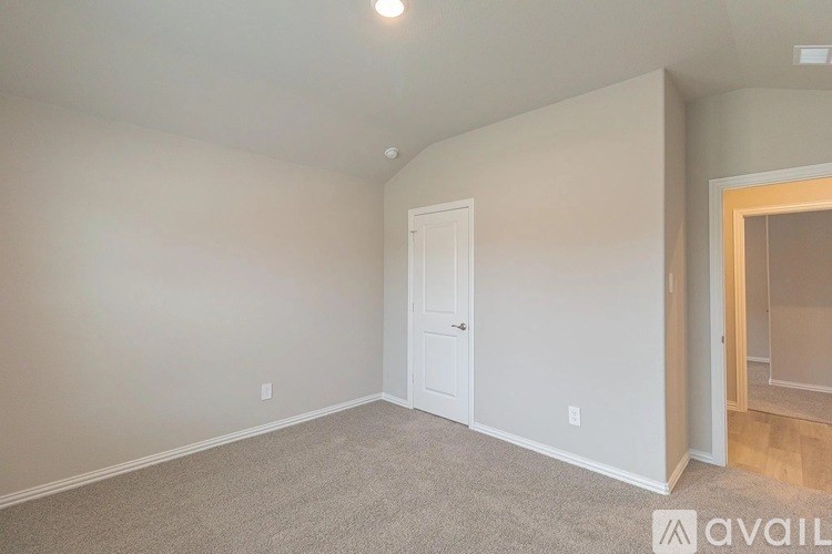 A room with a carpeted floor and a white door.