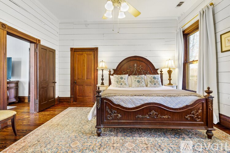 A bedroom with a large bed and wooden furniture.