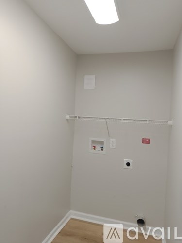 A white wall with a shelf and a few objects on it.