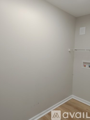 A room with a white wall and a wooden floor.