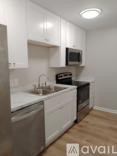 A kitchen with white cabinets and a stainless steel dishwasher.