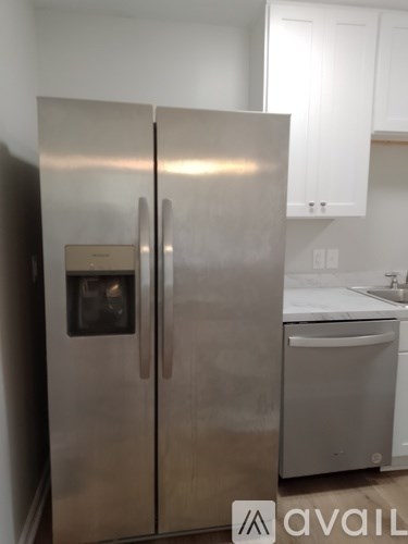 A stainless steel refrigerator with a water dispenser on the door.
