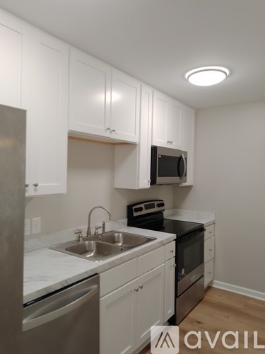 A kitchen with white cabinets and stainless steel appliances.