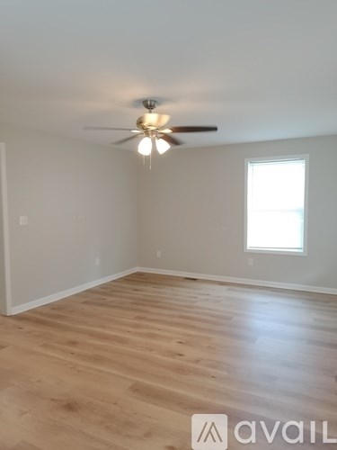 A room with a ceiling fan and a window.