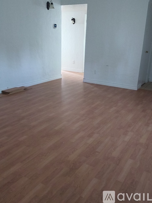 A room with wooden flooring and white walls.