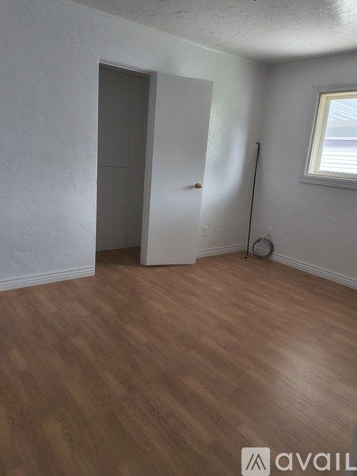 A room with wooden flooring and a white door.