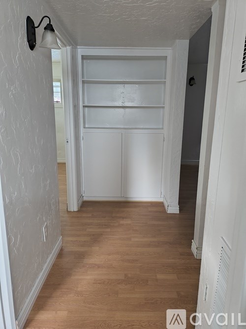 A hallway with a white door and a light on the wall.