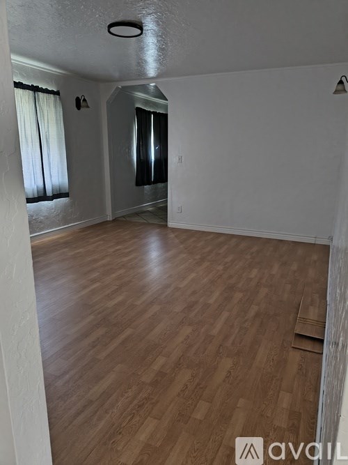 A room with wooden flooring and white walls.