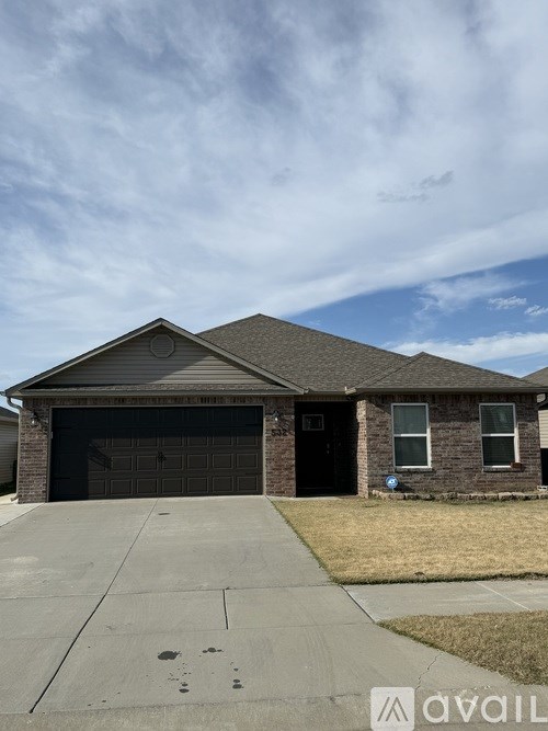 A house with a garage door and a driveway in front.