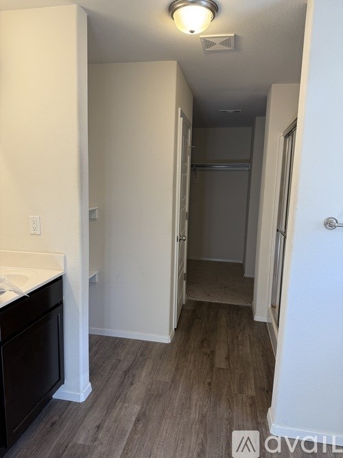 A bathroom with a sink and a wood floor.