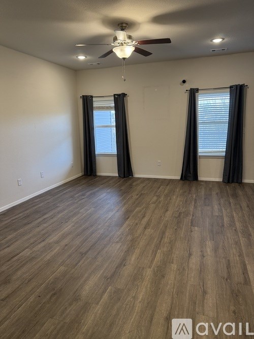 A room with wooden flooring and a ceiling fan.